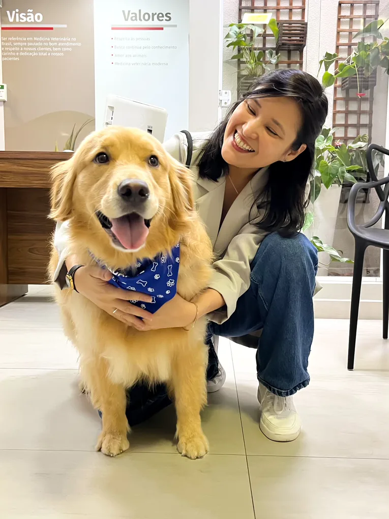 Veterinária do HV Levet com um cão na recepção do hospital